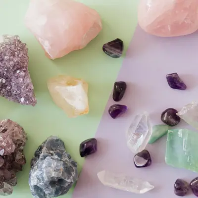 Crystals of various colours sitting on a green and purple surface.