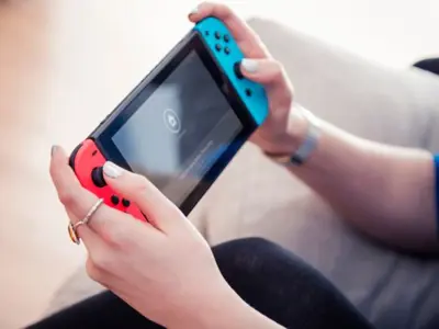 Hands holding a Nintendo Switch console.