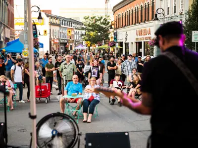 People gather on St. Paul Street of St. Catharines to watch live music.