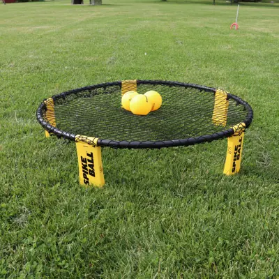 A Spikeball net and balls set up in a field.