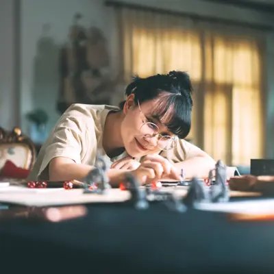 A young adult moving game pieces in a role-playing game.