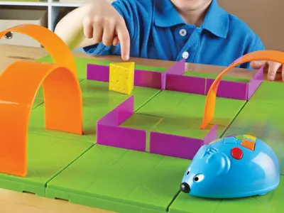 Child playing with a robot mouse exploring a maze.