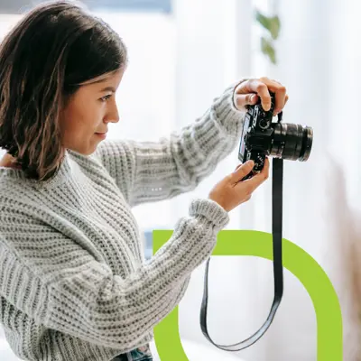 A woman holds up a camera preparing to take a photo.