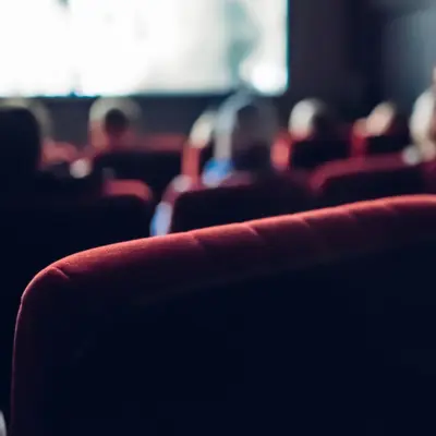A movie theatre viewed from the back of the theatre.