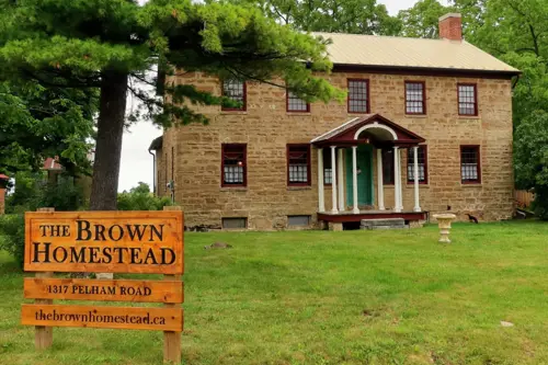 The front of The Brown Homestead with their wooden sign out front.
